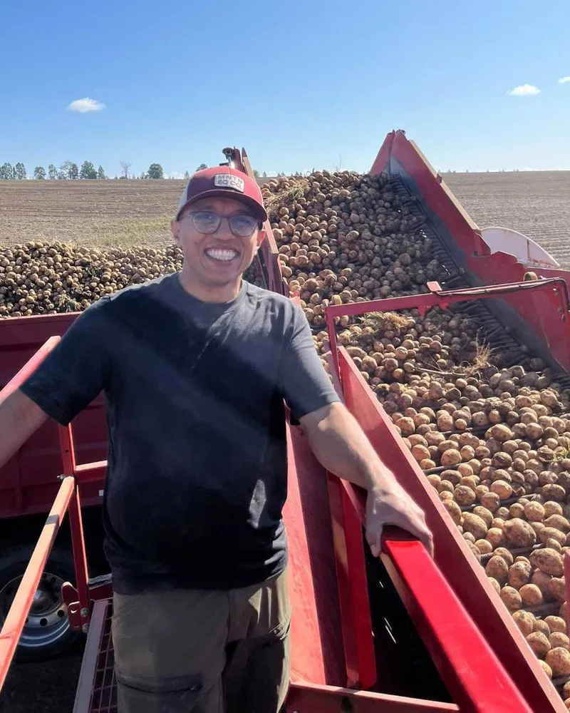 Zohaib Butt standing on a potato harvester during harvest